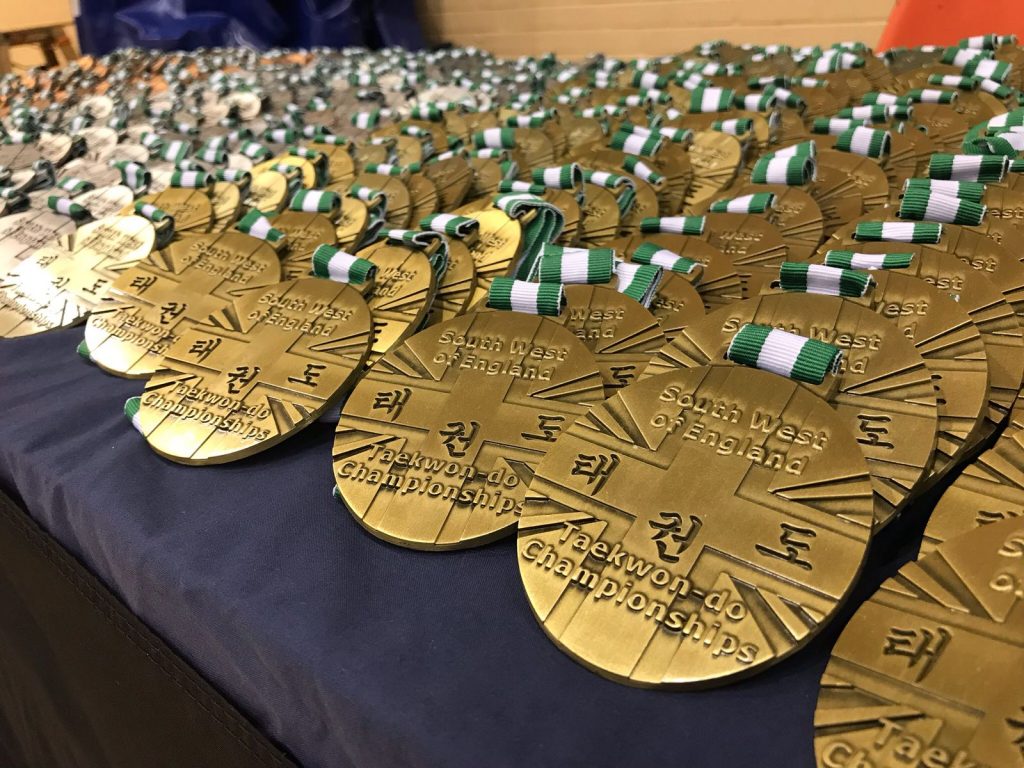 Picture on the medals displayed out over a table at the SW Open Taekwondo Championships May 2018 Hosted By Torbay Taekwondo Schools