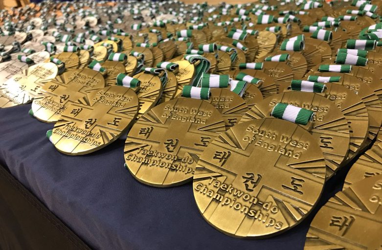 Picture on the medals displayed out over a table at the SW Open Taekwondo Championships May 2018 Hosted By Torbay Taekwondo Schools