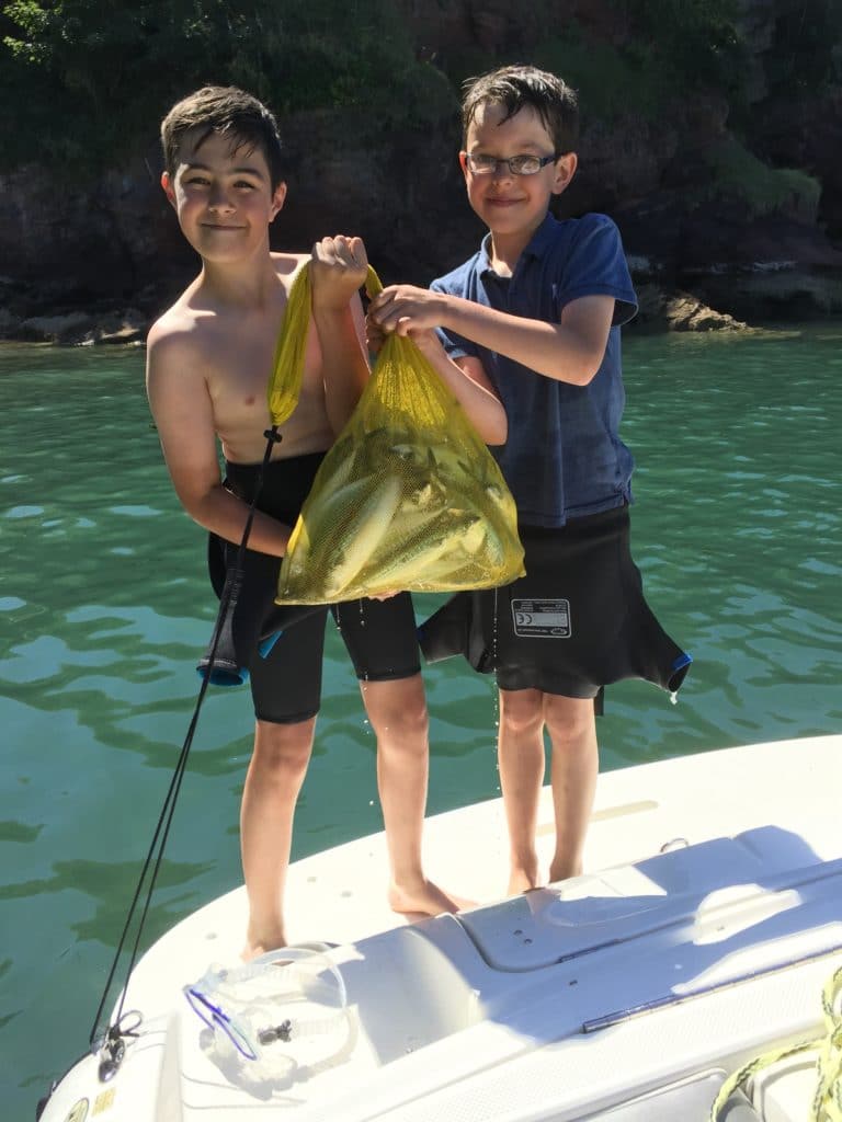 Torbay taekwondo students holding a large bag of fish